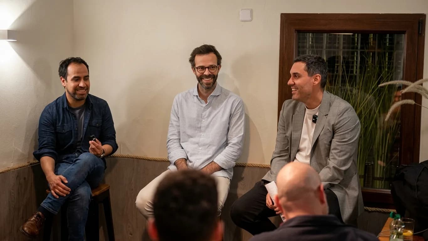 Tres invitados charlando y riendo sentados ante los miembros en una sesión de The Boom Club